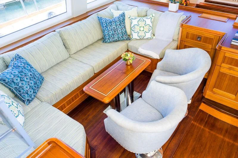 a living room with a couch and a table aboard NAKUPENDA Yacht for Sale