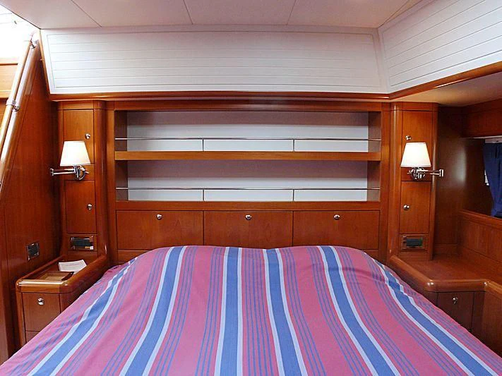 a bed with a purple and white striped sheet aboard NAKUPENDA Yacht for Sale