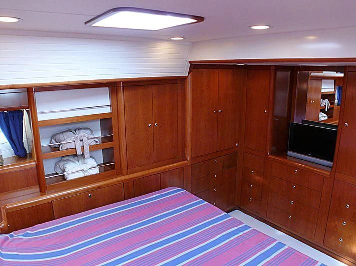 a room with a bed and a television aboard NAKUPENDA Yacht for Sale