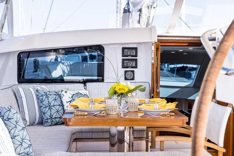 a living room with a table and couches aboard NAKUPENDA Yacht for Sale