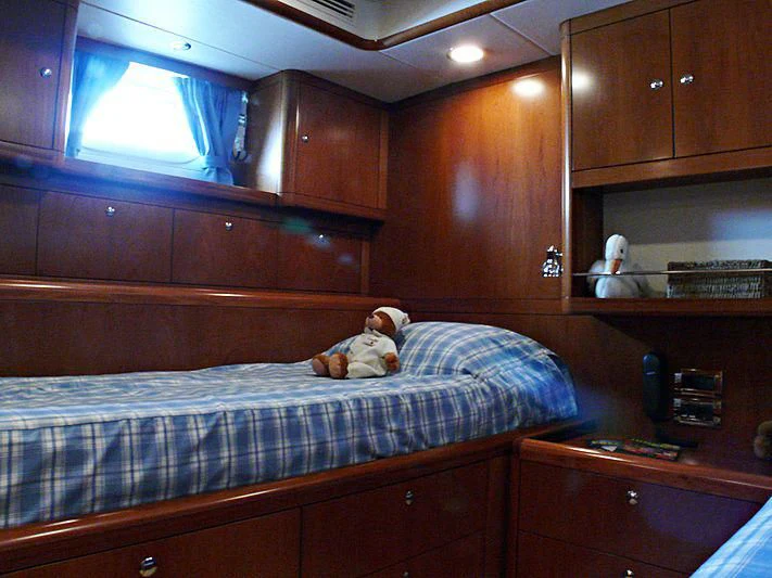 a bedroom with a bed and cabinets aboard NAKUPENDA Yacht for Sale