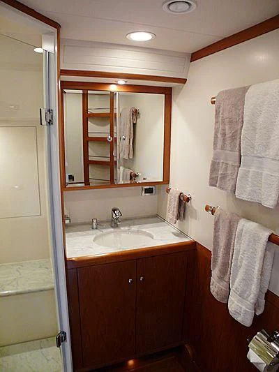 a bathroom with a mirror and towels aboard NAKUPENDA Yacht for Sale
