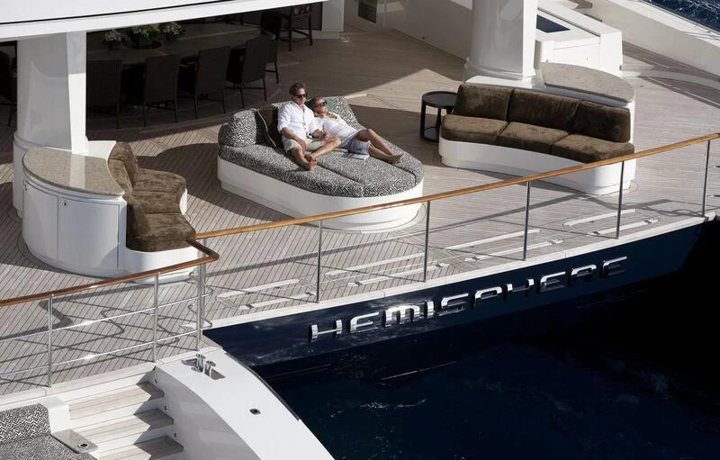 a couple of people sitting on a couch in a large room aboard HEMISPHERE Yacht for Sale