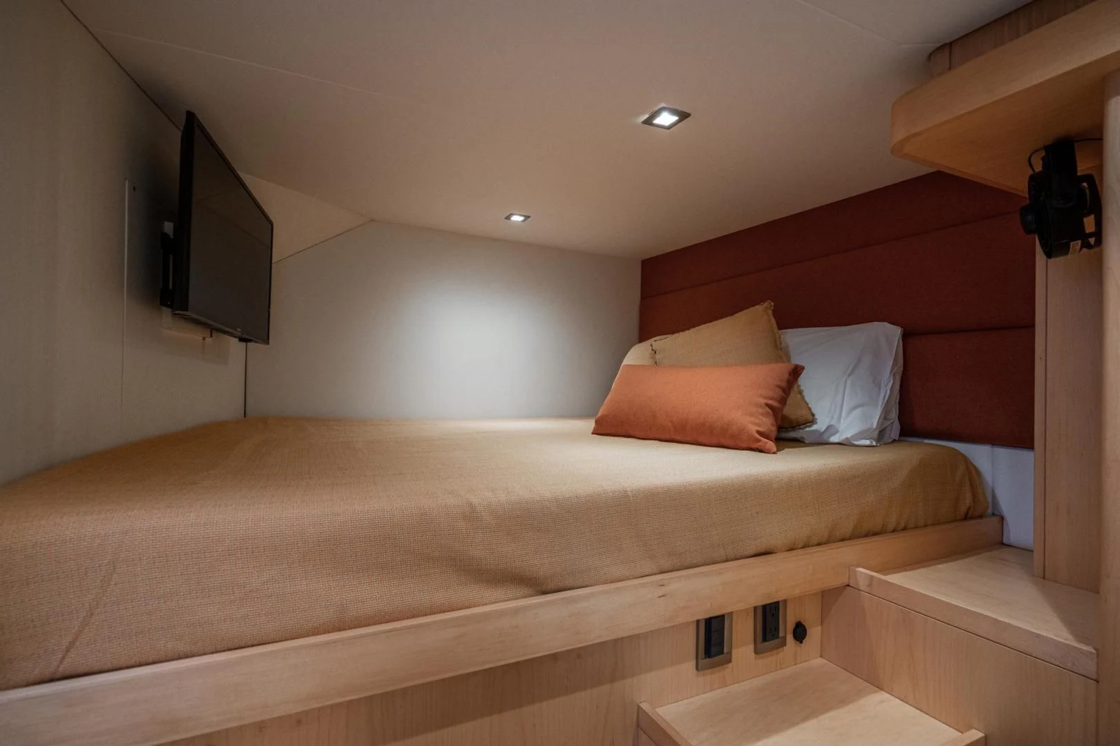 a bed with a television on the wall aboard MY CAT Yacht for Sale