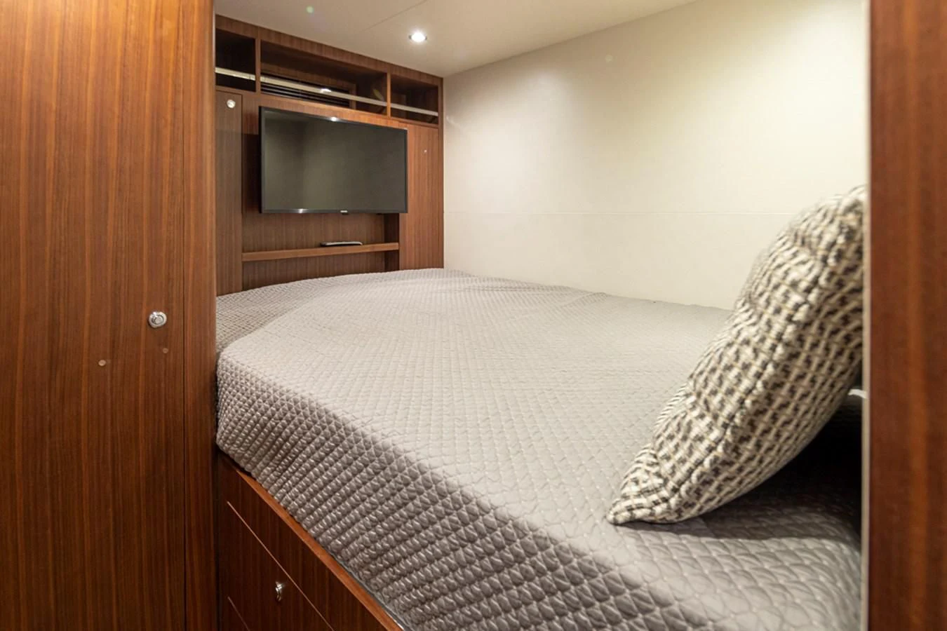 a bed with a television on the wall aboard HYAK Yacht for Sale