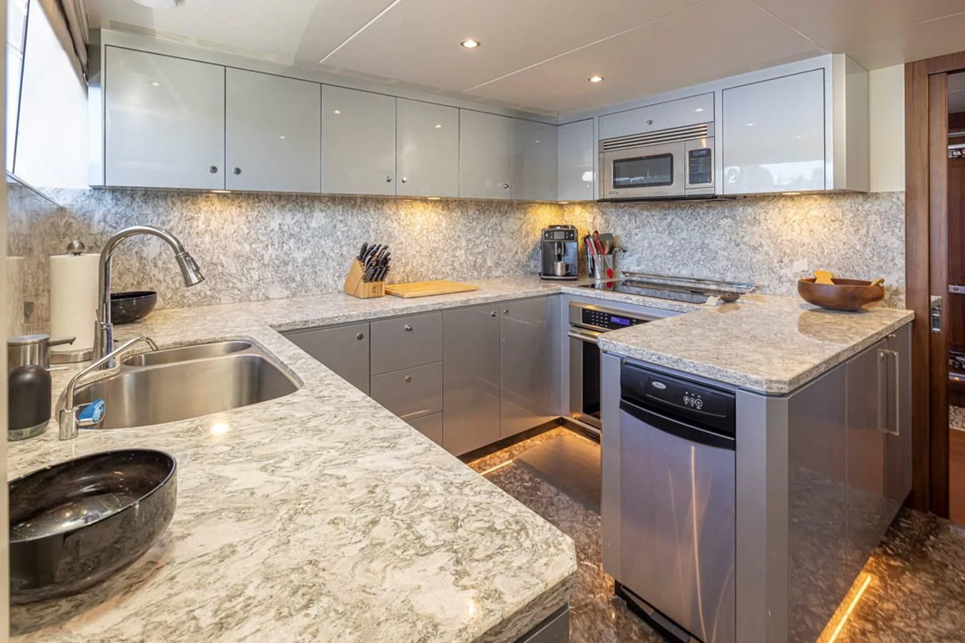 a kitchen with white cabinets aboard HYAK Yacht for Sale