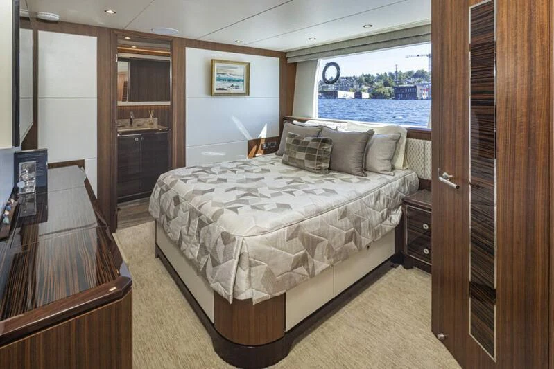 a bedroom with a bed and a wood door aboard HYAK Yacht for Sale