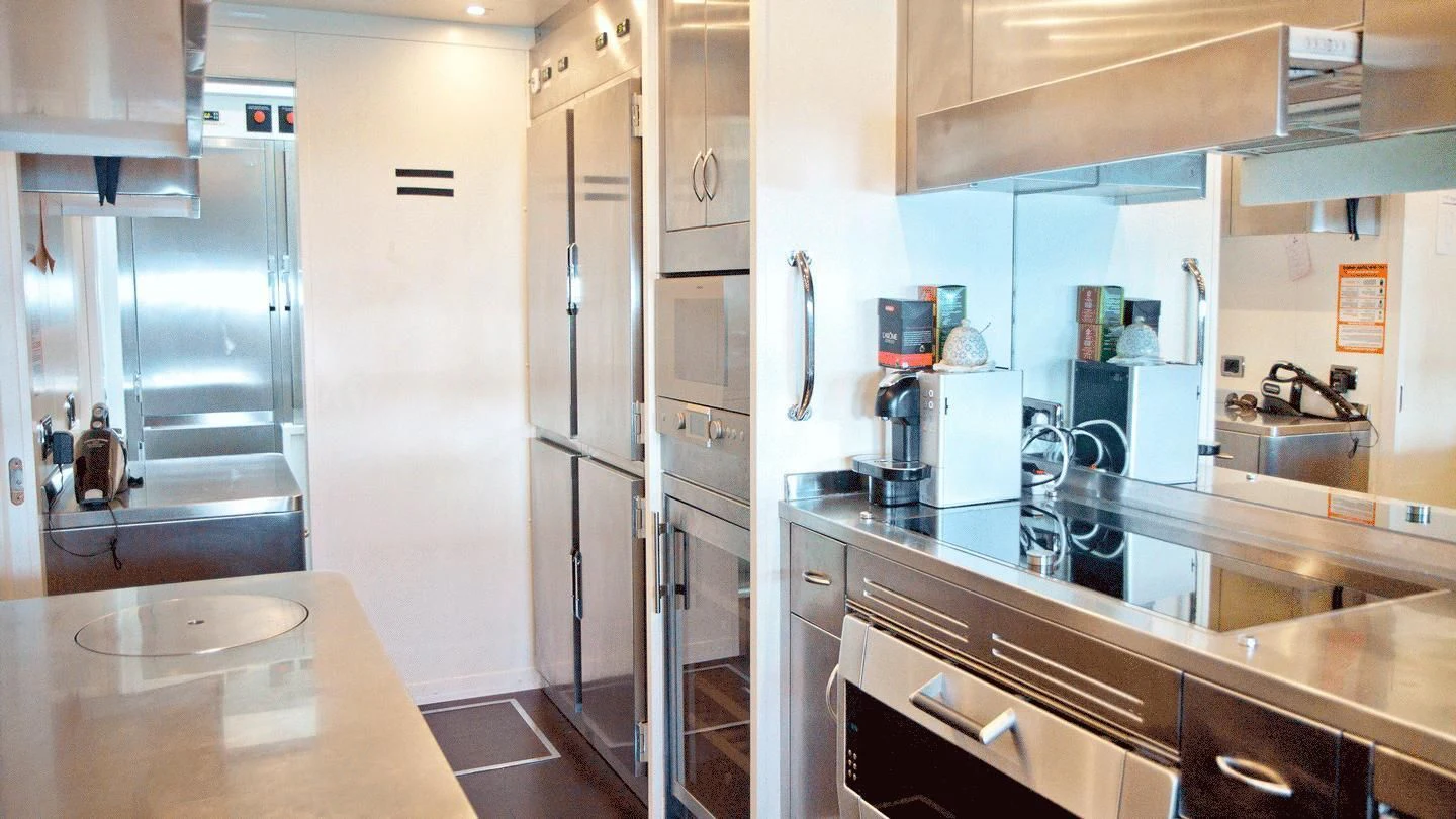 a kitchen with a table and refrigerator aboard ALLURE A Yacht for Sale