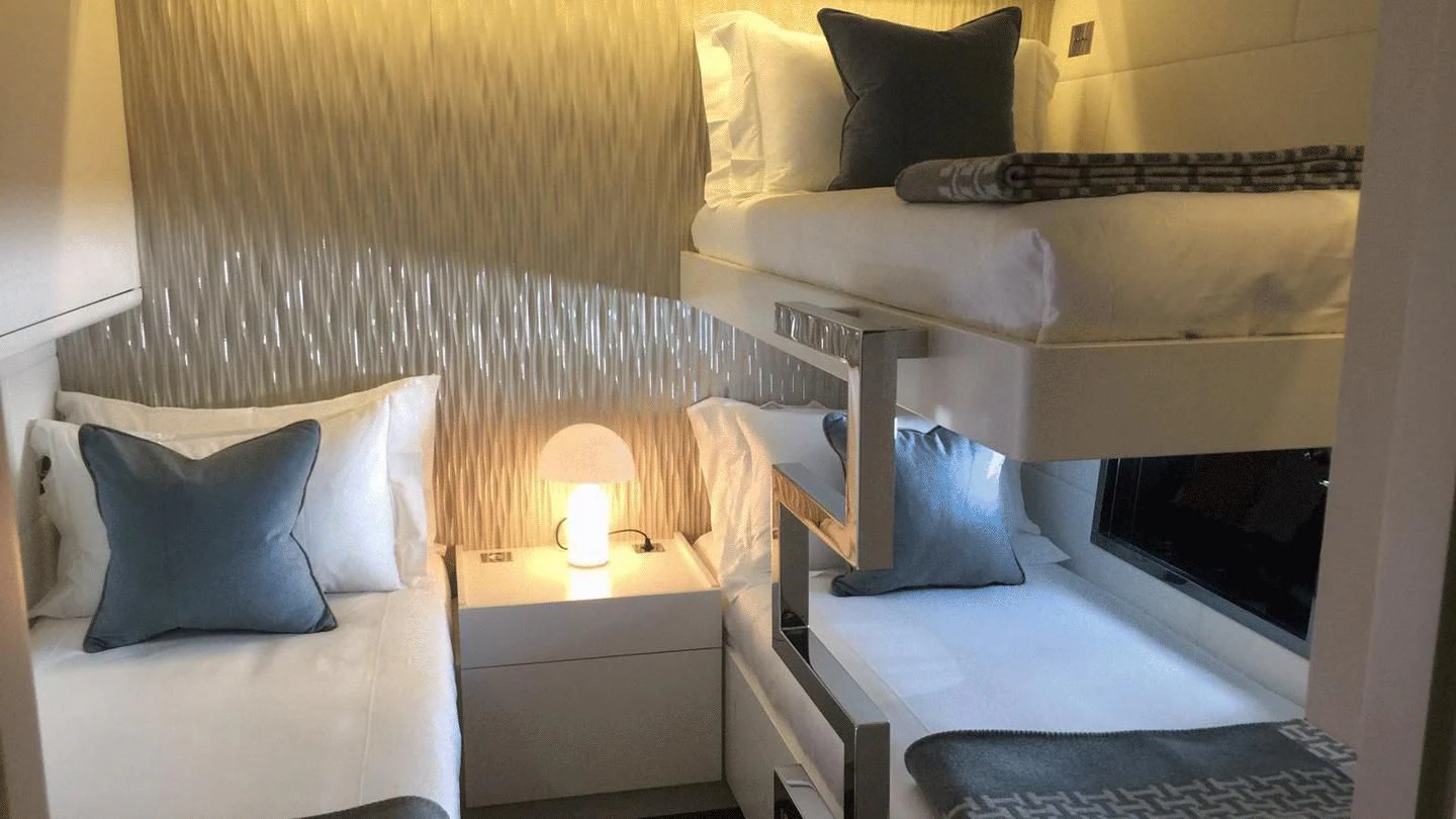 a bed with a bed and a lamp on it aboard ALLURE A Yacht for Sale