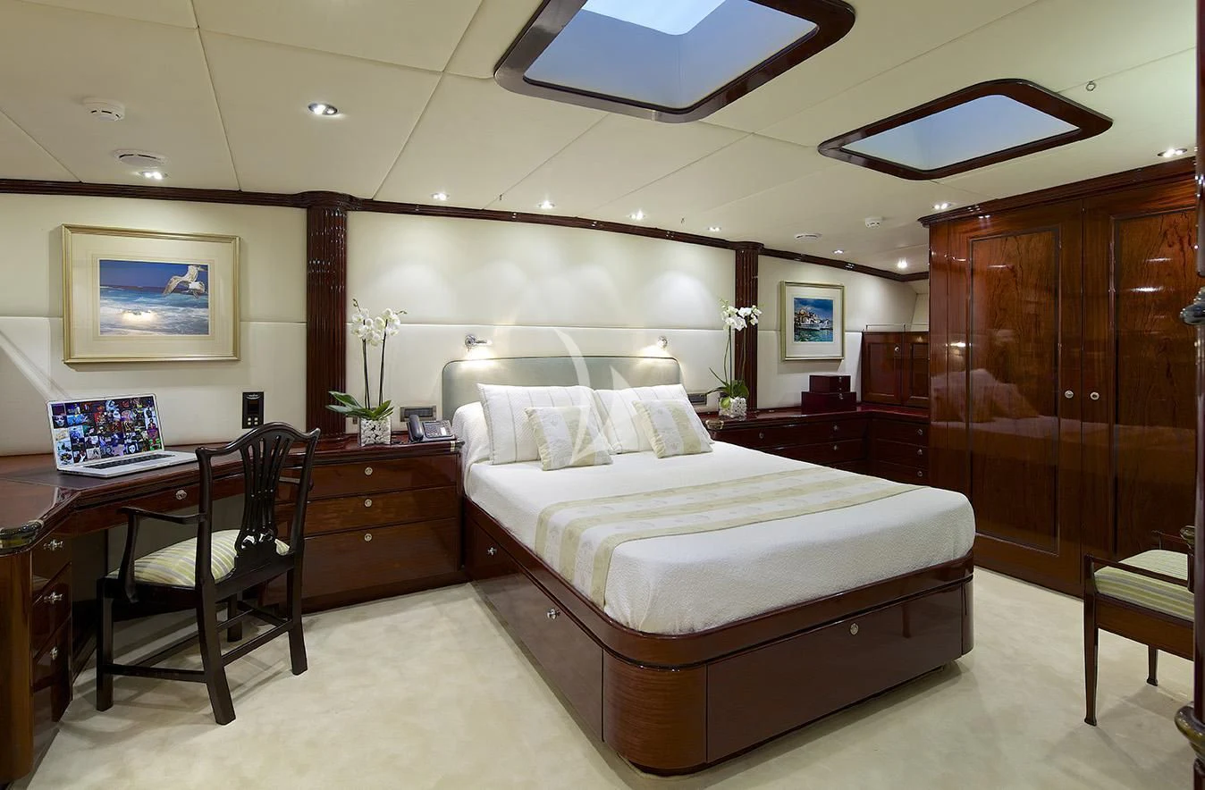 a bedroom with a bed and desk aboard ALLURE A Yacht for Sale