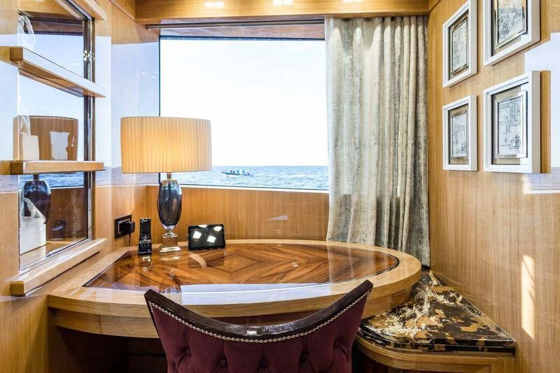 a table with a lamp and a window aboard VIATORIS Yacht for Sale