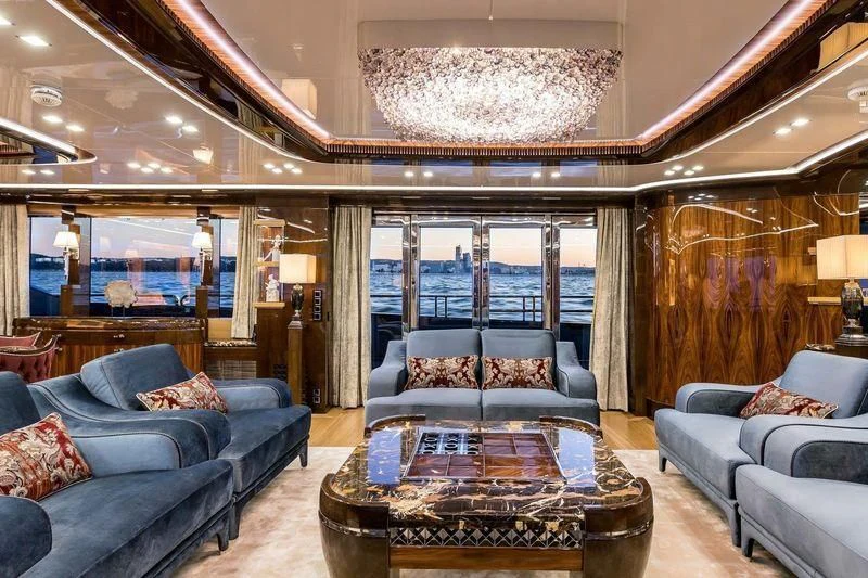 a living room with a large chandelier aboard VIATORIS Yacht for Sale