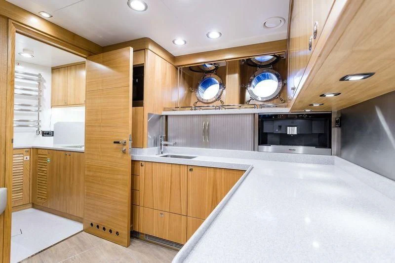 a kitchen with wooden cabinets aboard VIATORIS Yacht for Sale