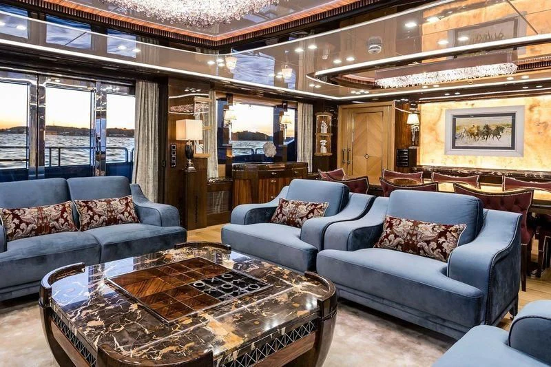 a living room with a large chandelier aboard VIATORIS Yacht for Sale