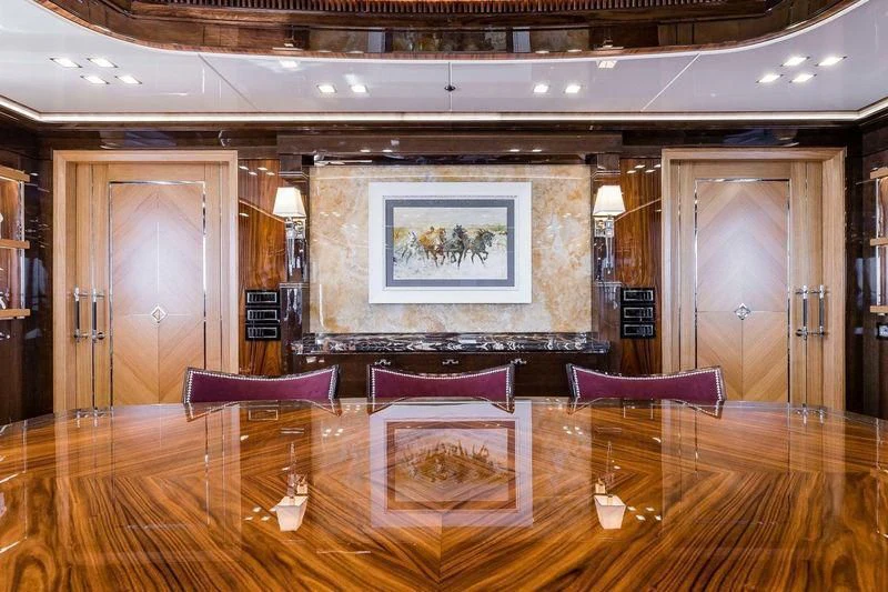 a room with a wood floor and a large mirror on the wall aboard VIATORIS Yacht for Sale