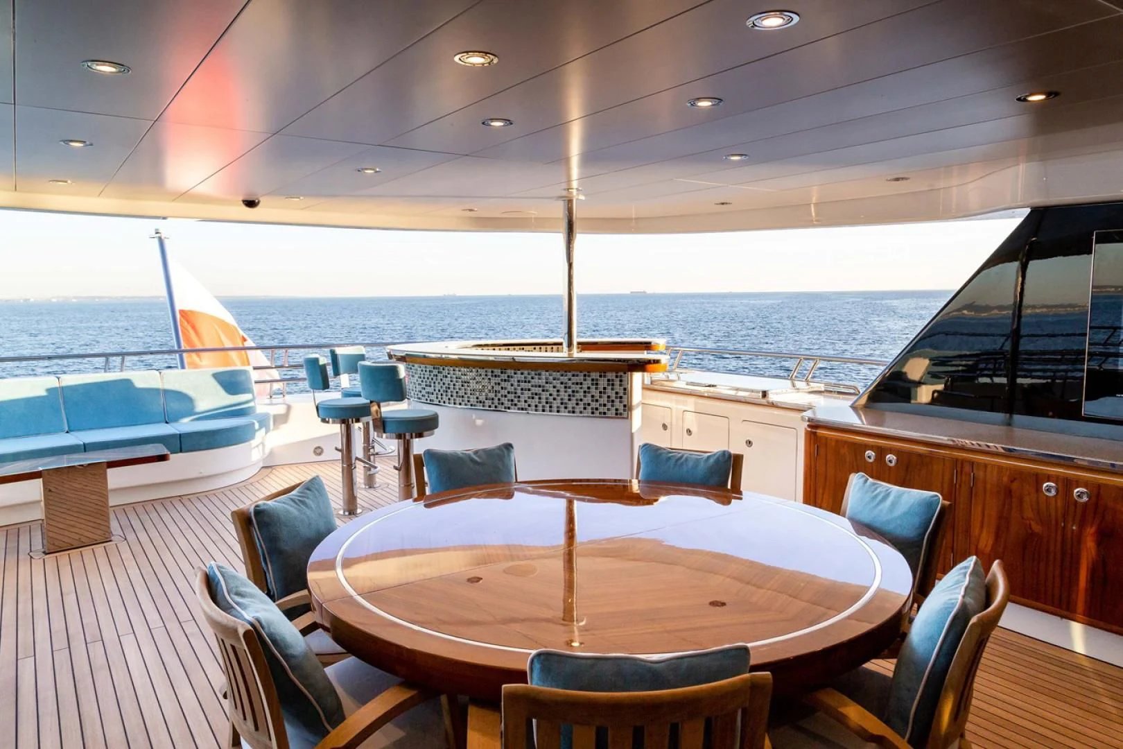 a large room with a table and chairs and a large ship in the background aboard VIATORIS Yacht for Sale