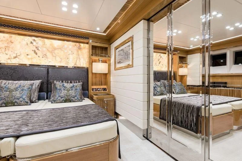 a bedroom with a bed and a large mirror aboard VIATORIS Yacht for Sale