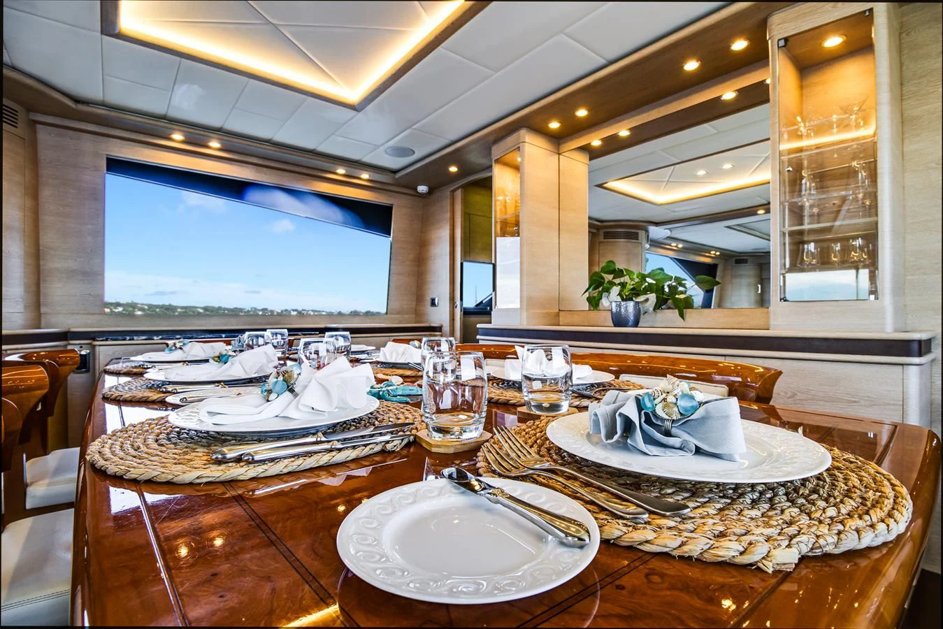 a large dining table with plates and glasses on it aboard GRACE Yacht for Sale