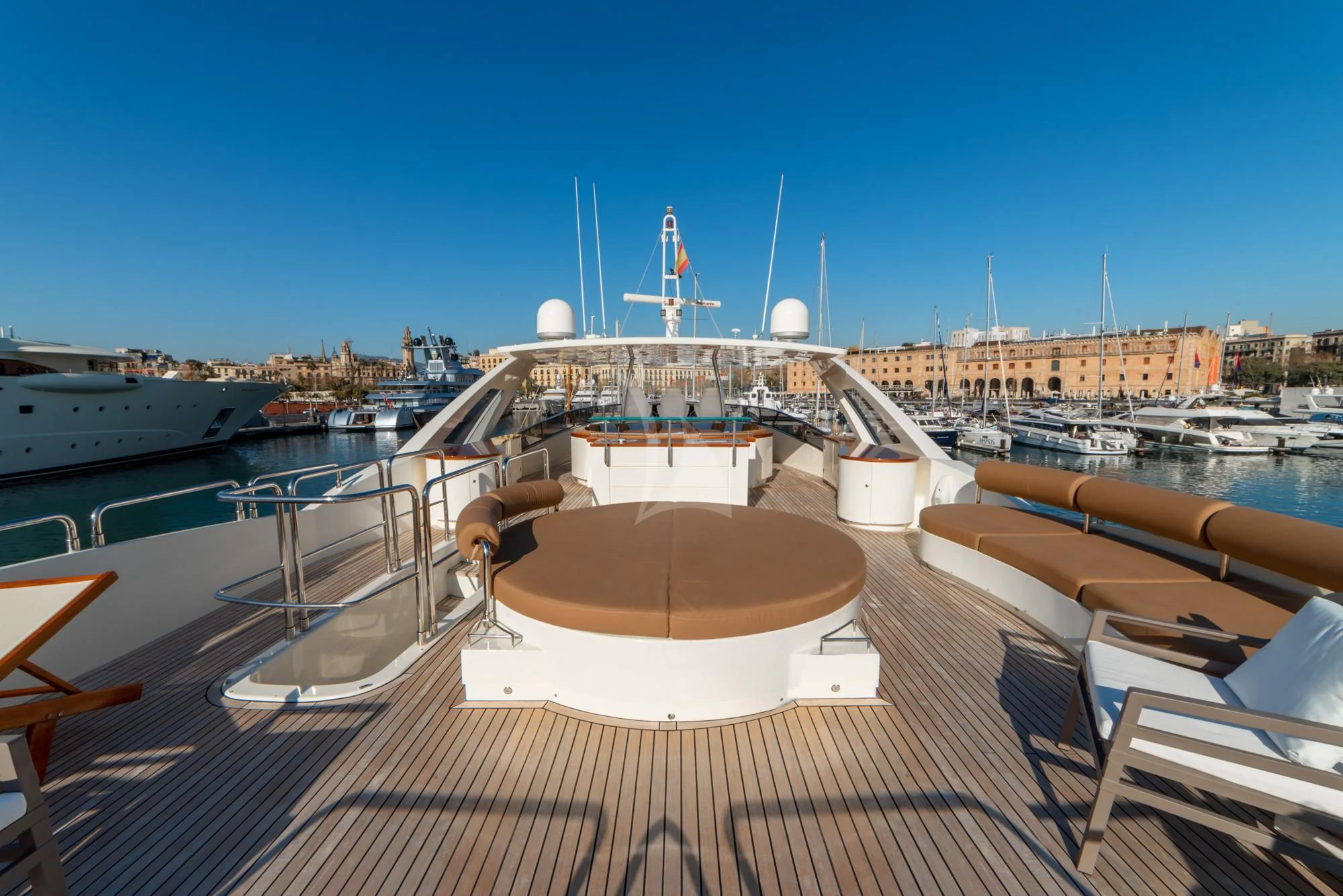 a deck with a view of a city and a large ship in the water aboard GRACE Yacht for Sale