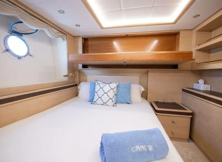 a room with a bed and a shelf with a mirror above it aboard GRACE Yacht for Sale