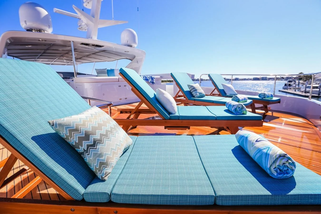 a deck with solar panels and a pool with a building and a boat in the background aboard HUNTER Yacht for Sale