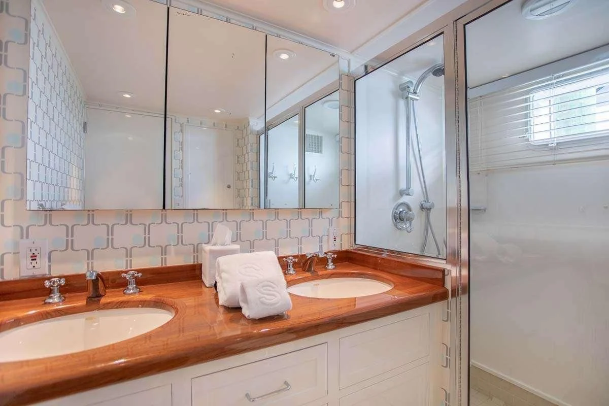 a bathroom with two sinks and a large mirror aboard SOVEREIGN Yacht for Charter