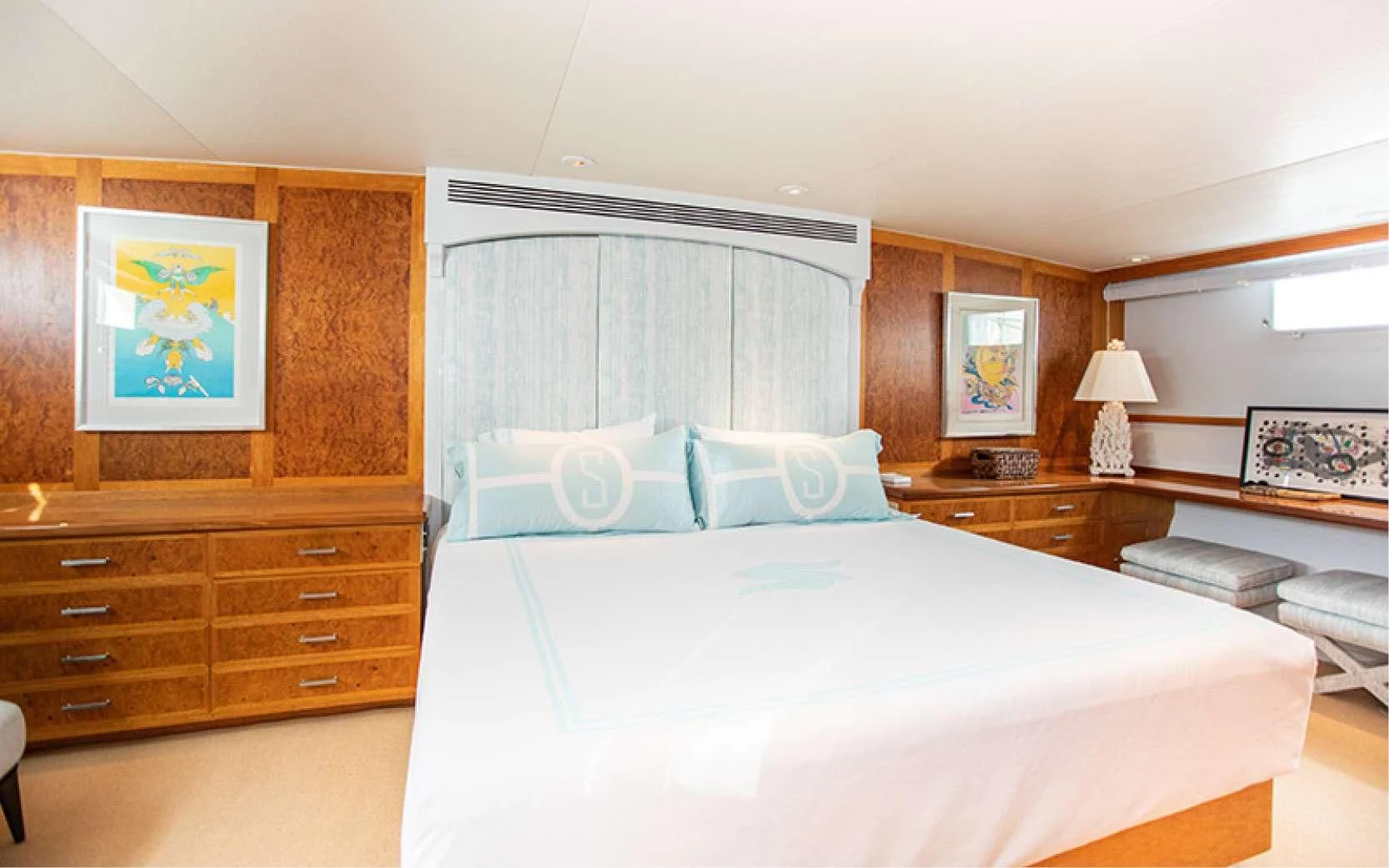 a bedroom with a bed and a dresser aboard SOVEREIGN Yacht for Charter