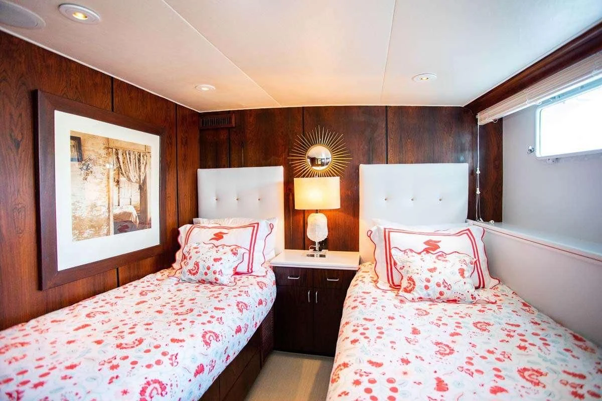 a couple of beds in a hotel room aboard SOVEREIGN Yacht for Charter
