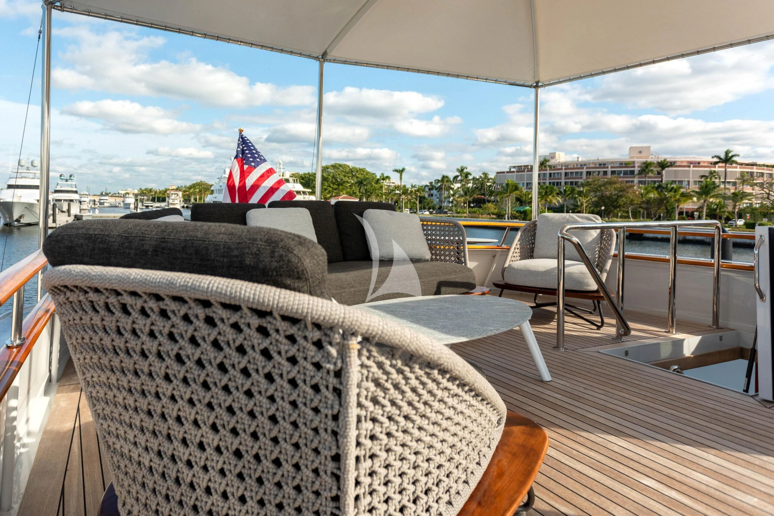 a deck with chairs and a flag aboard SOVEREIGN Yacht for Charter