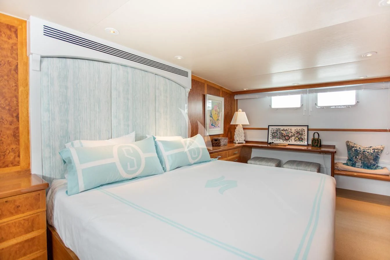 a bedroom with a bed and a desk aboard SOVEREIGN Yacht for Charter
