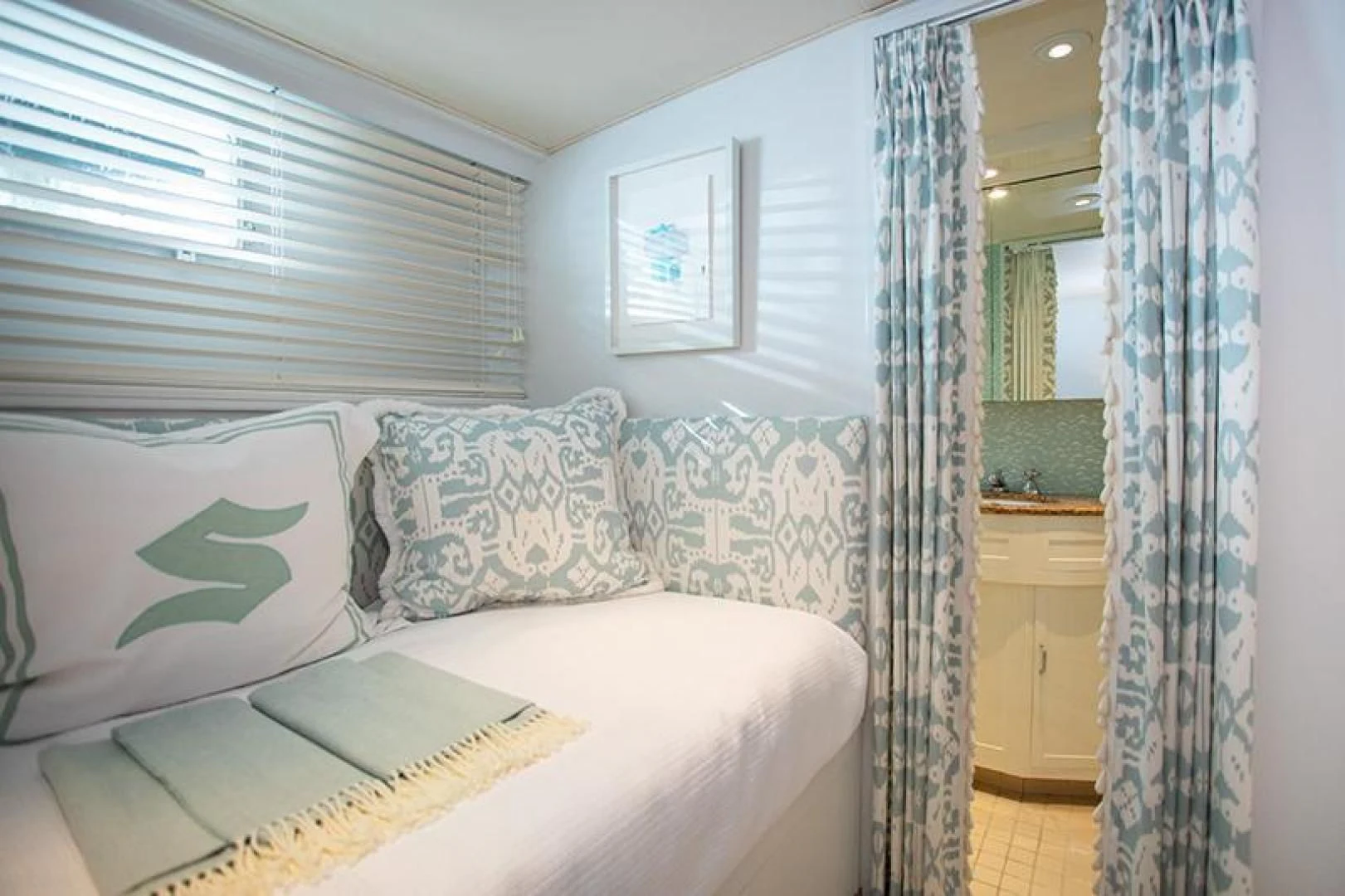 a bed with a book on it aboard SOVEREIGN Yacht for Charter