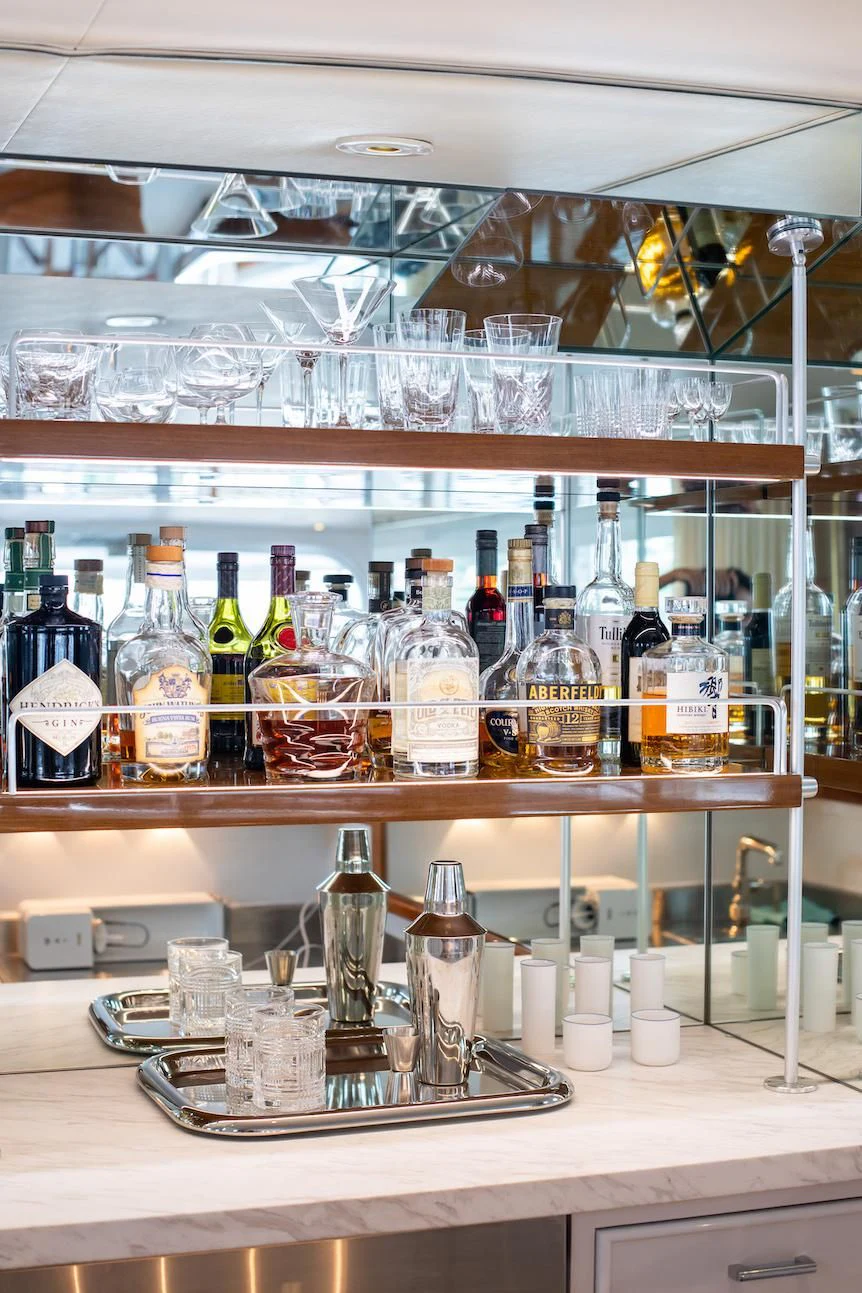 a shelf with bottles and glasses aboard SOVEREIGN Yacht for Charter