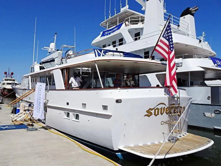 a boat with a flag on the front aboard SOVEREIGN Yacht for Charter