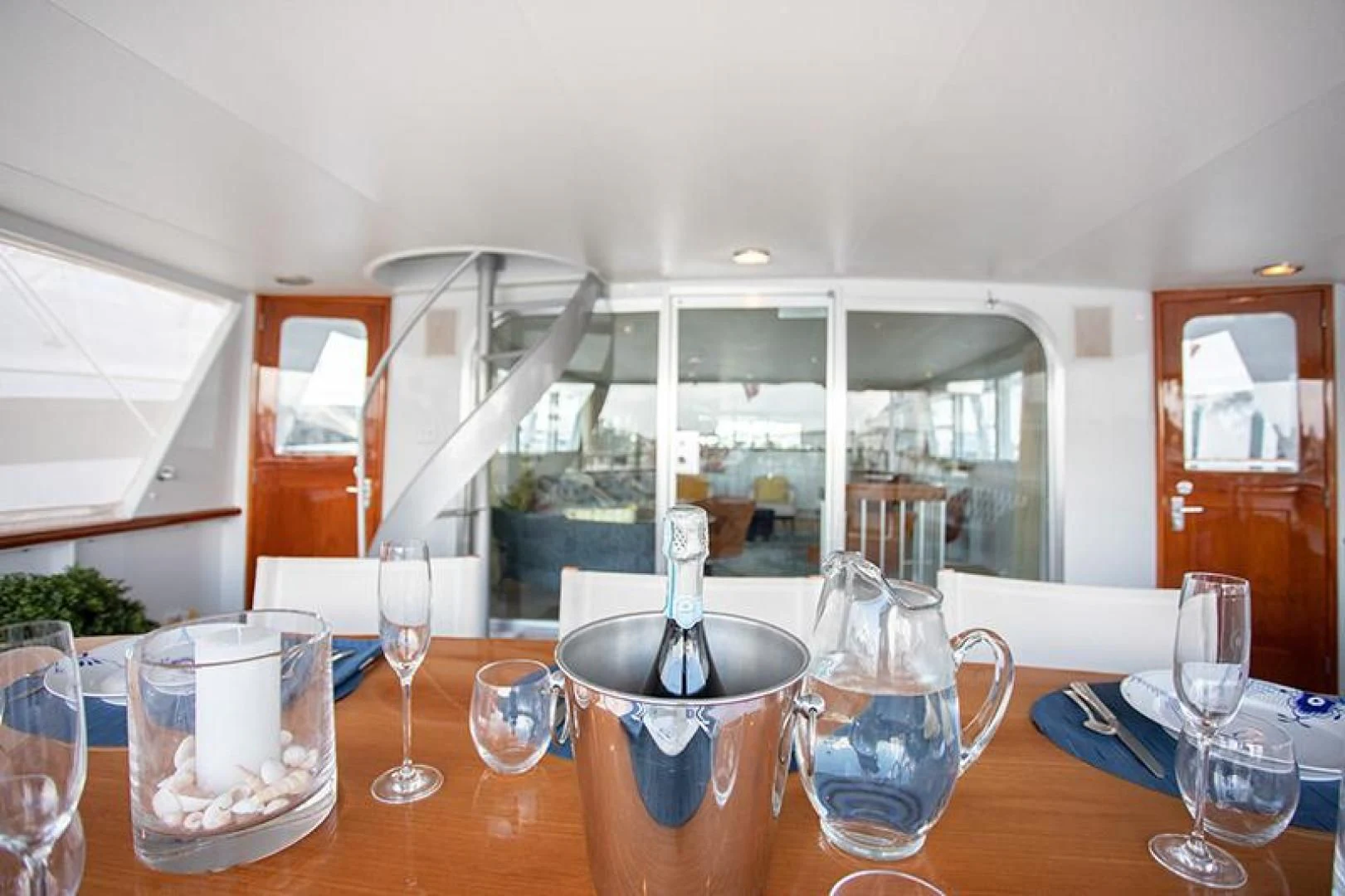 a table with wine glasses and a vase on it aboard SOVEREIGN Yacht for Charter