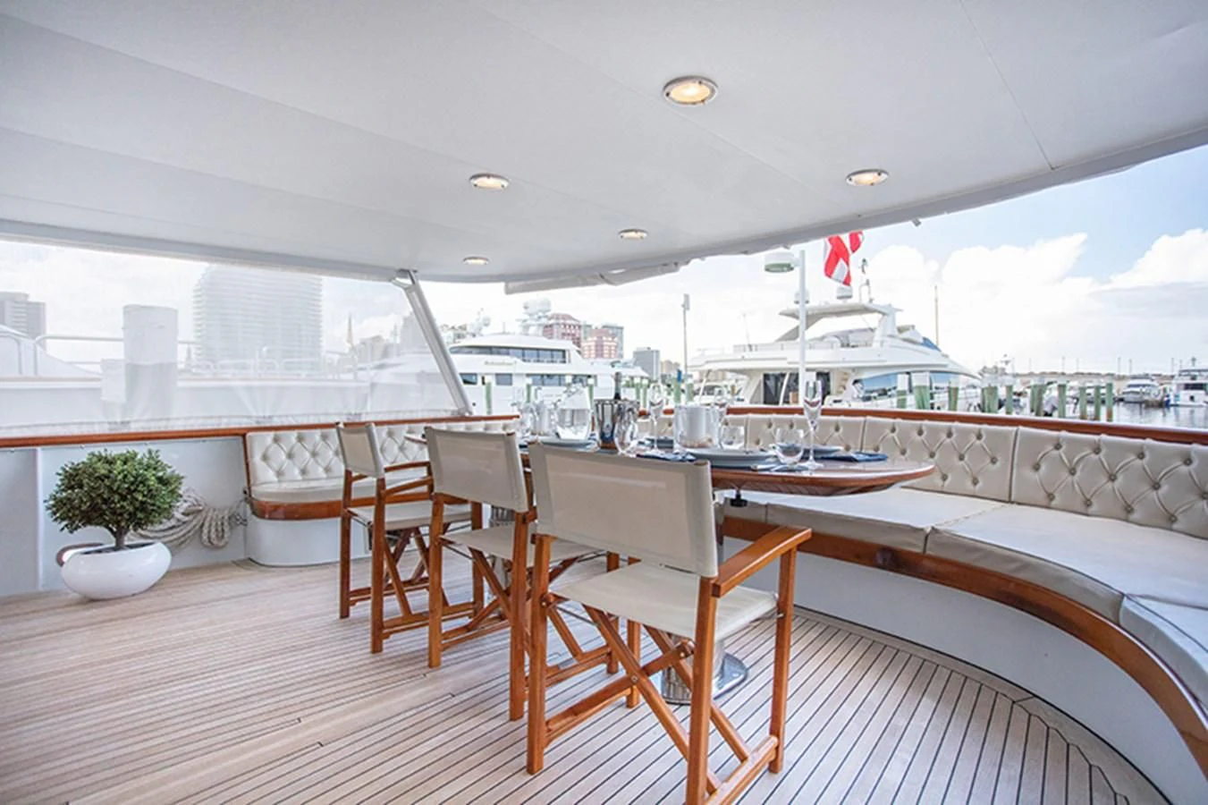 a room with a table chairs and a large window overlooking a large ship aboard SOVEREIGN Yacht for Charter