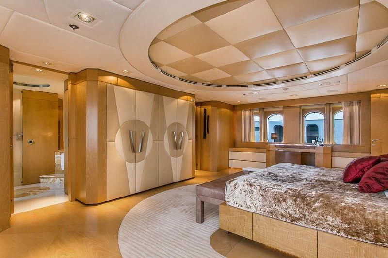 a large room with a bed and a large mirror aboard BACA Yacht for Charter