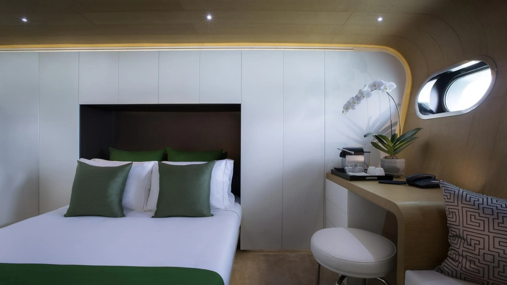 a bed with a white bed and green pillows aboard OCEAN EMERALD Yacht for Sale