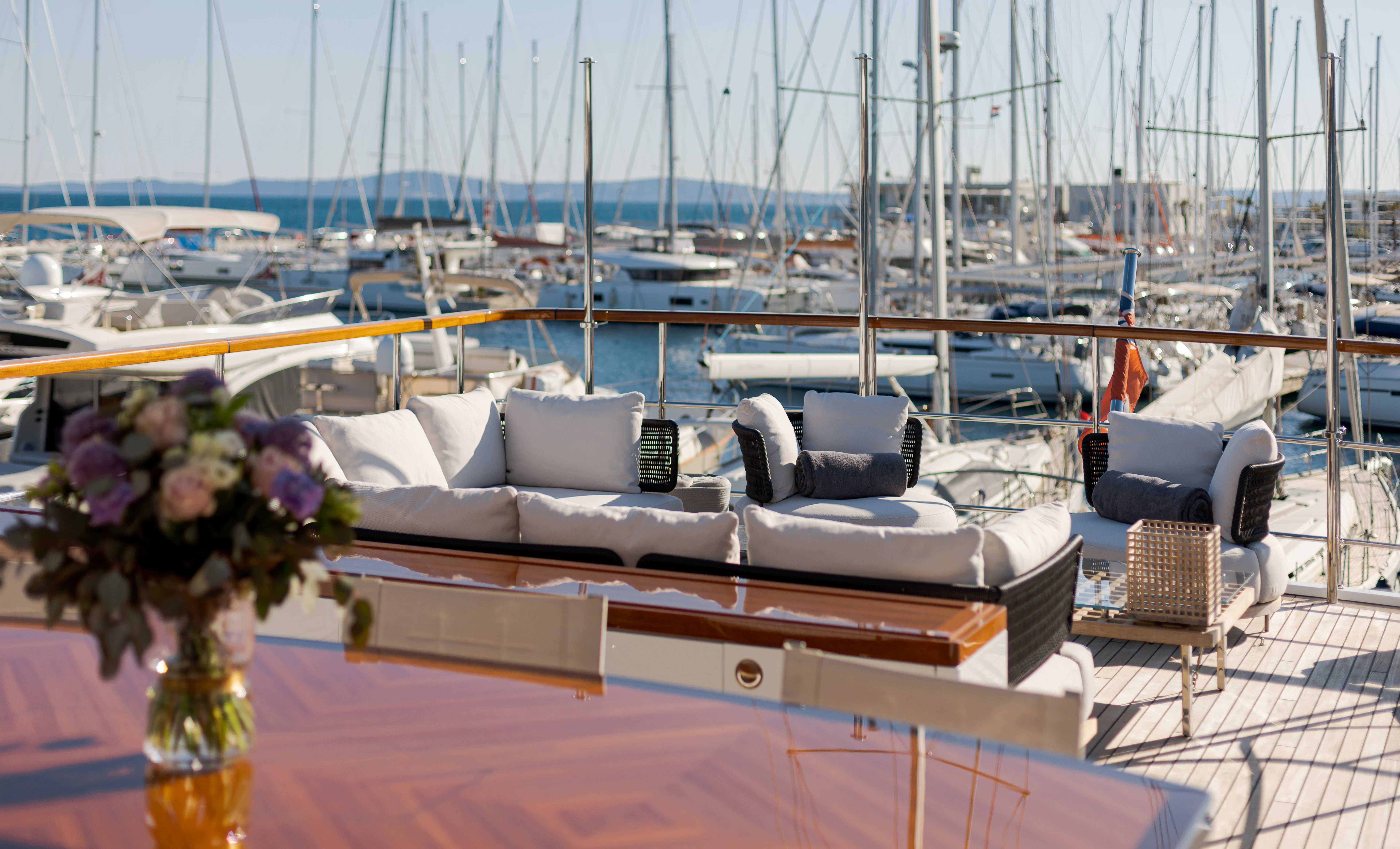 a large patio with a table and chairs and a vase with flowers aboard BELLA VITA Yacht for Charter