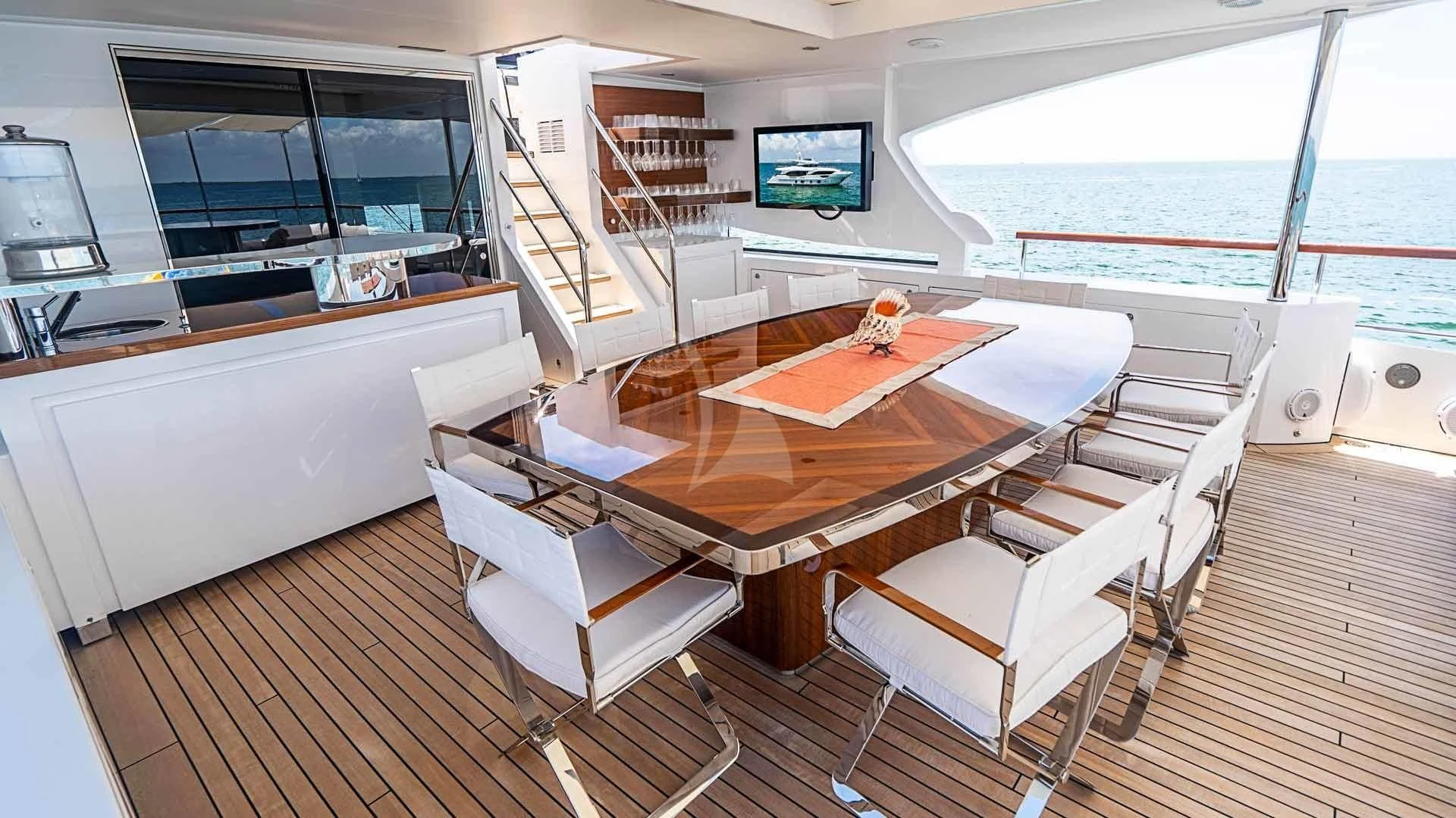 a room with a table chairs and a tv aboard BELLA VITA Yacht for Charter