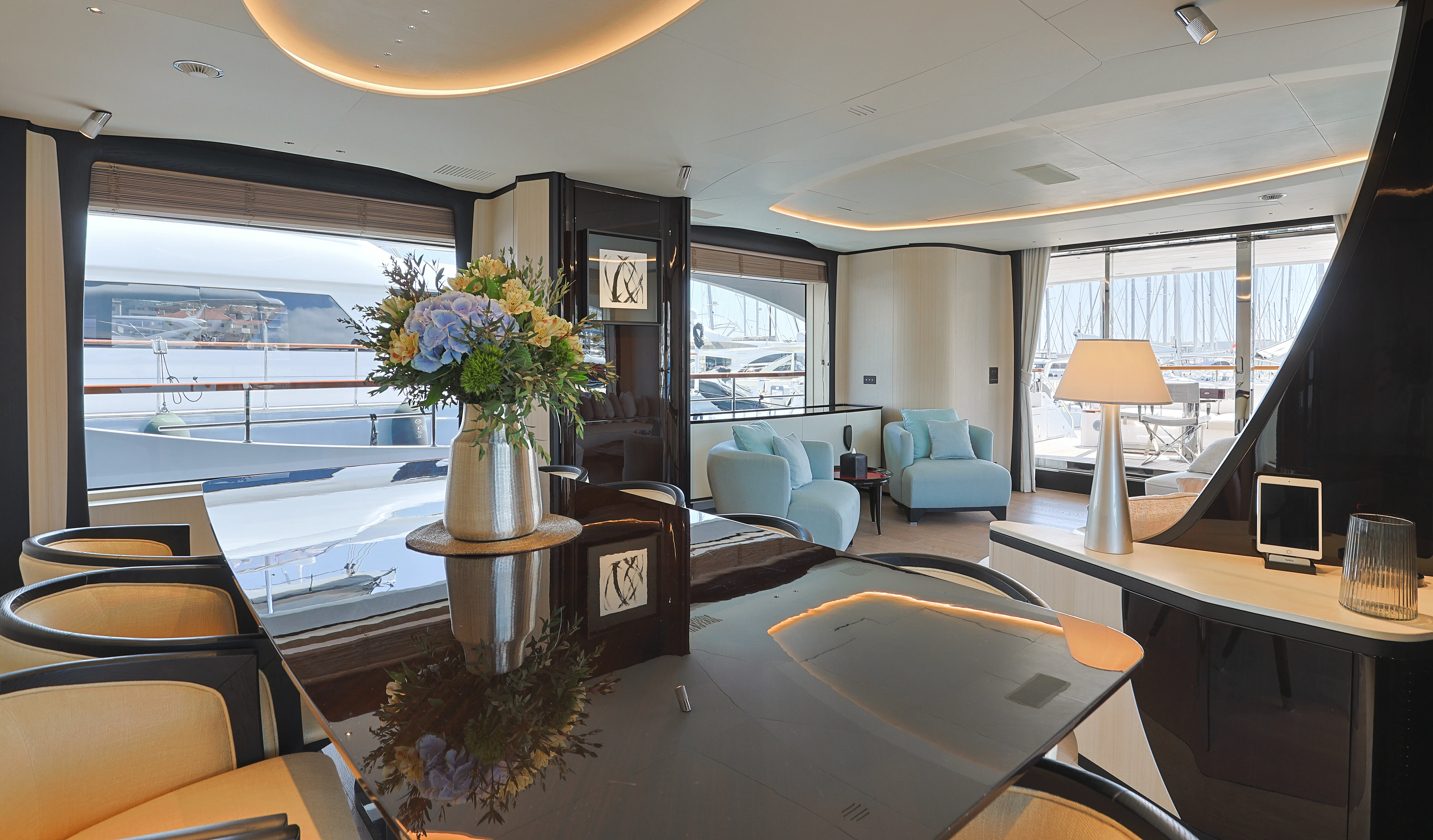 a room with a table chairs and a vase with flowers in it aboard BELLA VITA Yacht for Charter