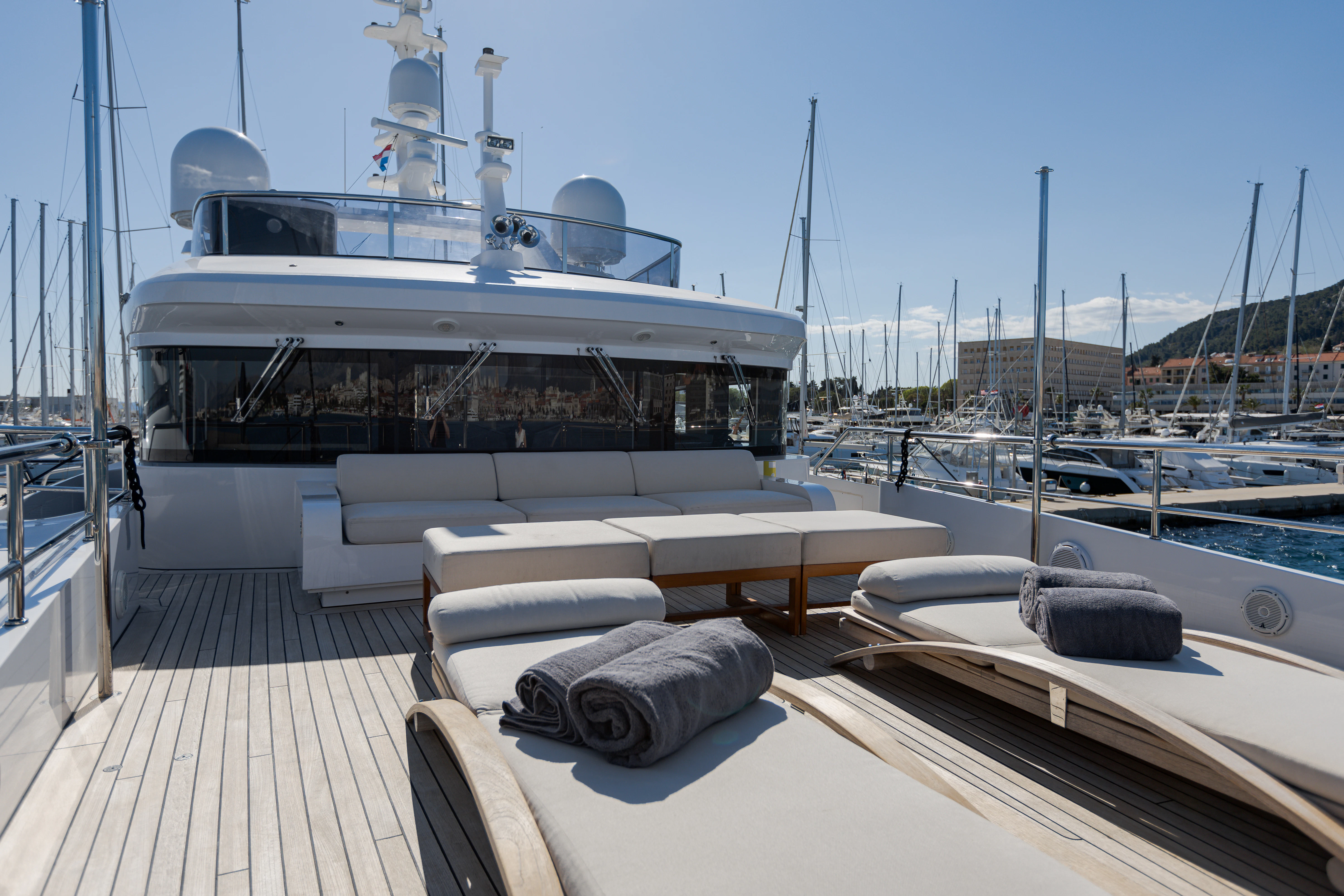 a deck with a large yacht in the background aboard BELLA VITA Yacht for Charter