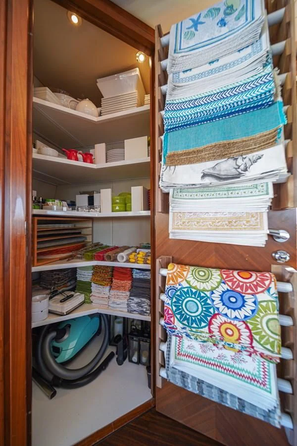 a shelf with books and clothes on it aboard EL TIO Yacht for Sale