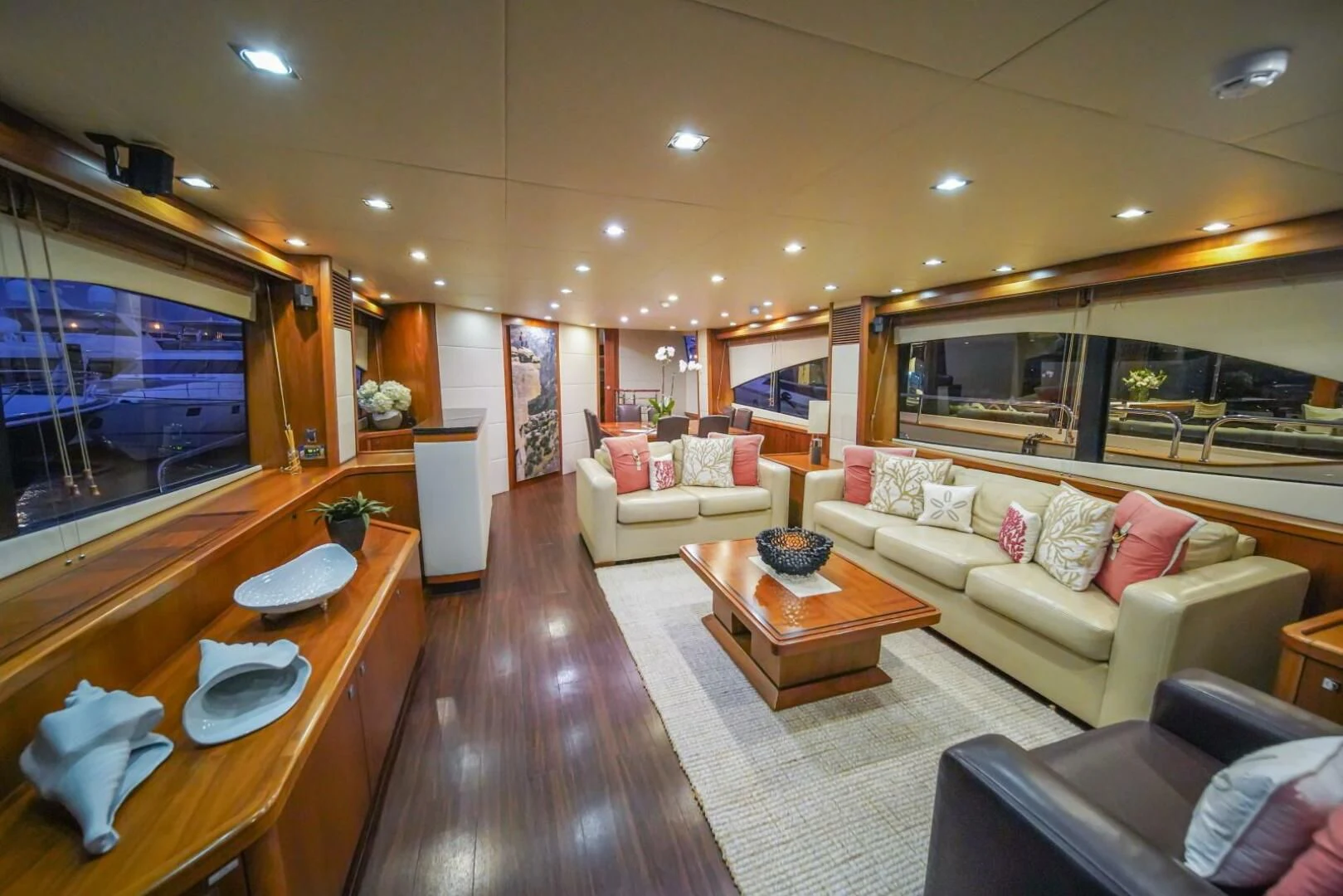 a living room with a wood table and a large screen television aboard EL TIO Yacht for Sale