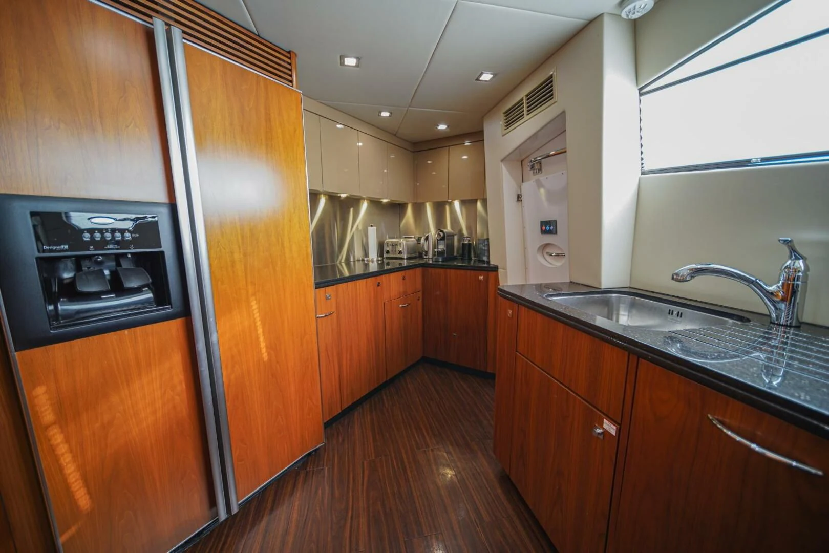 a kitchen with wooden cabinets aboard EL TIO Yacht for Sale