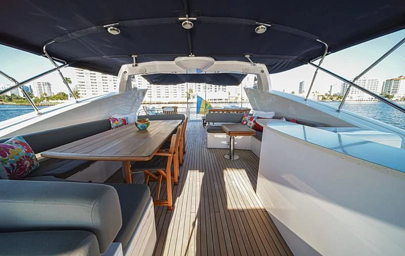 a deck with a table and chairs aboard EL TIO Yacht for Sale