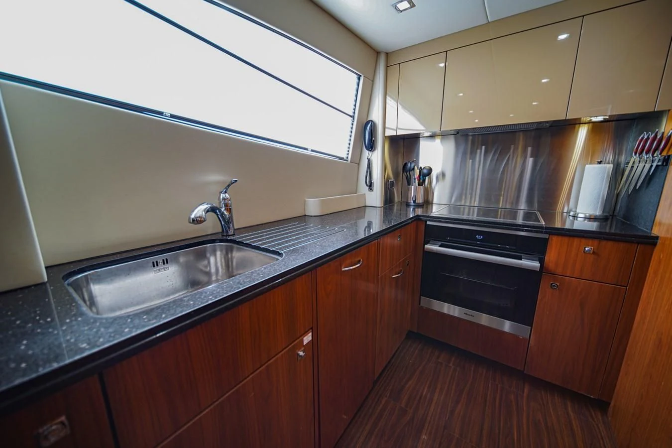 a kitchen with wooden cabinets aboard EL TIO Yacht for Sale