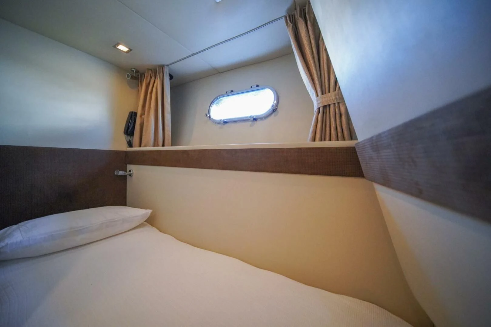 a bed with a window aboard EL TIO Yacht for Sale