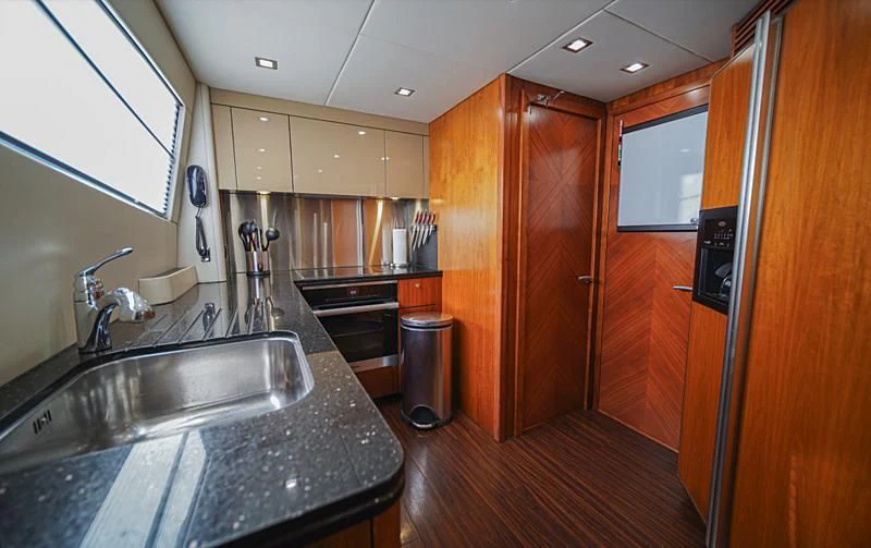 a kitchen with wooden cabinets aboard EL TIO Yacht for Sale
