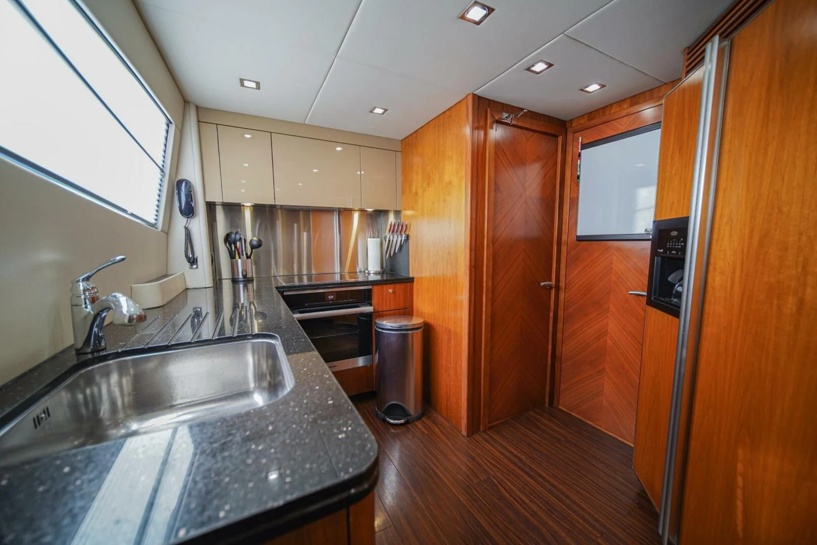 a kitchen with wooden cabinets aboard EL TIO Yacht for Sale