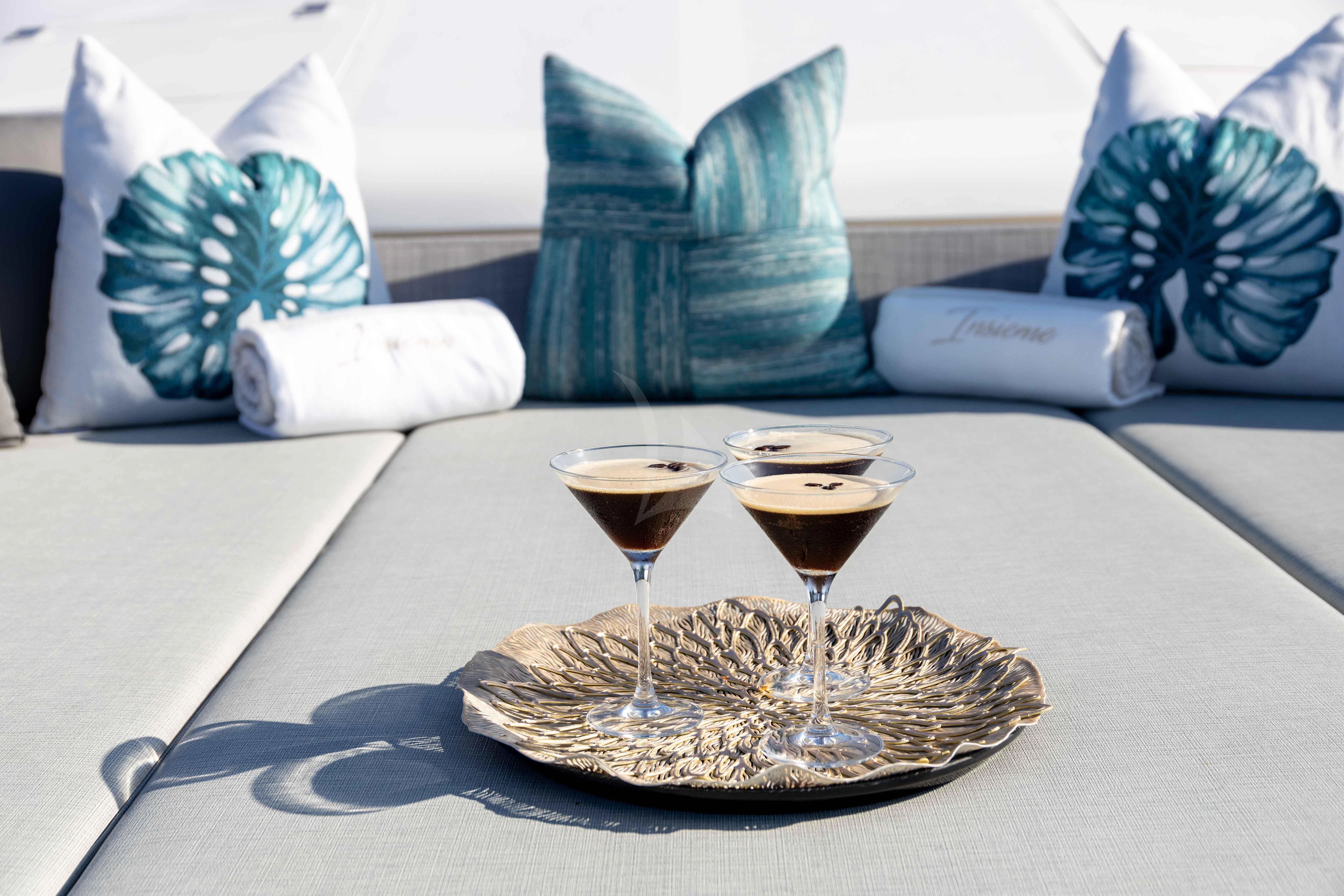 a plate of food and glasses of wine on a table aboard INSIEME Yacht for Sale